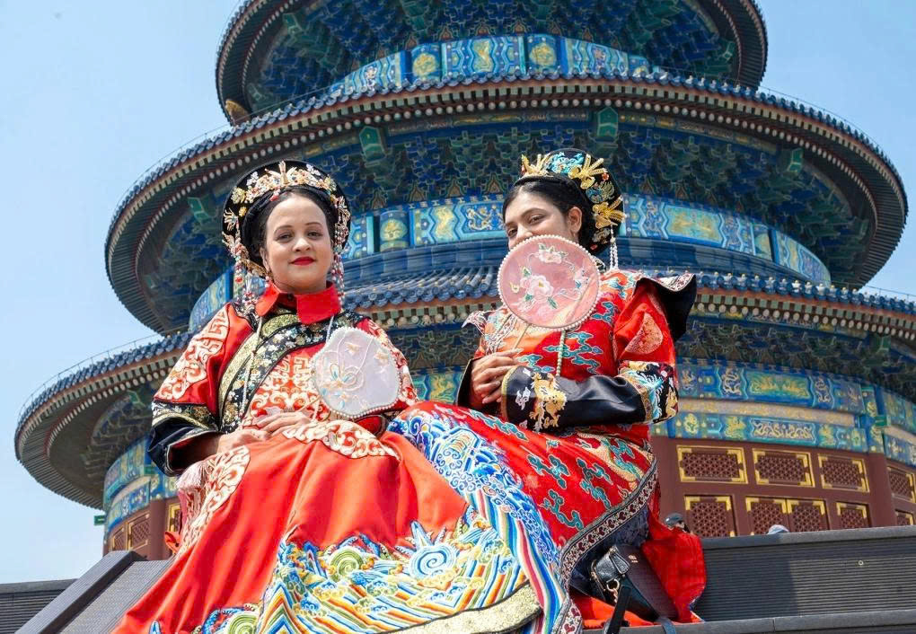 China Extends Visa Exemption for 45 Countries Foreign visitors wearing traditional attire take photos at the Temple of Heaven in Beijing. Photo: China Daily.