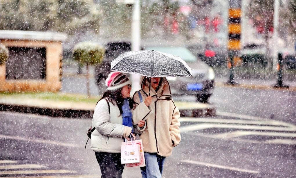 Early Mid-Autumn Snowfall Blankets Northern China People use umbrellas while walking in the snow during autumn in Harbin, Heilongjiang Province, on October 19. Photo: IC.