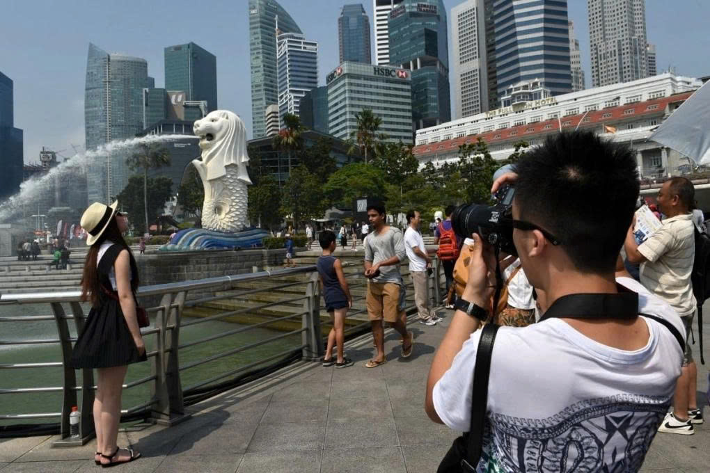 Chinese tourists flock to take souvenir photos with the famous Merlion statue in Singapore. Photo: SCMP.